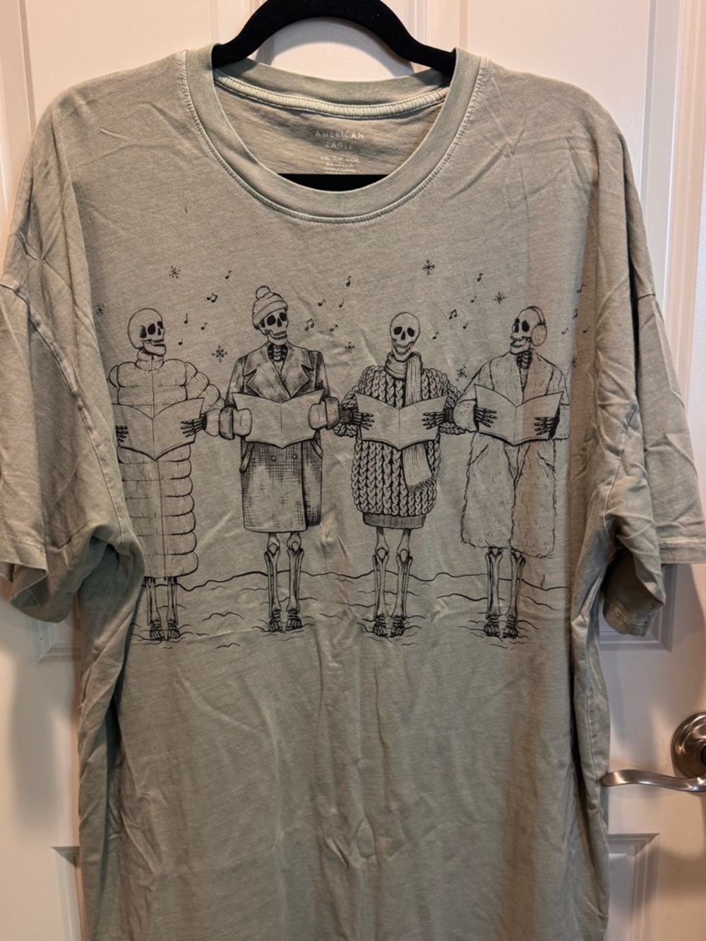 American Eagle Women 
Light Sage Graphic Crew Neck T-Shirt - Skeleton Carolers